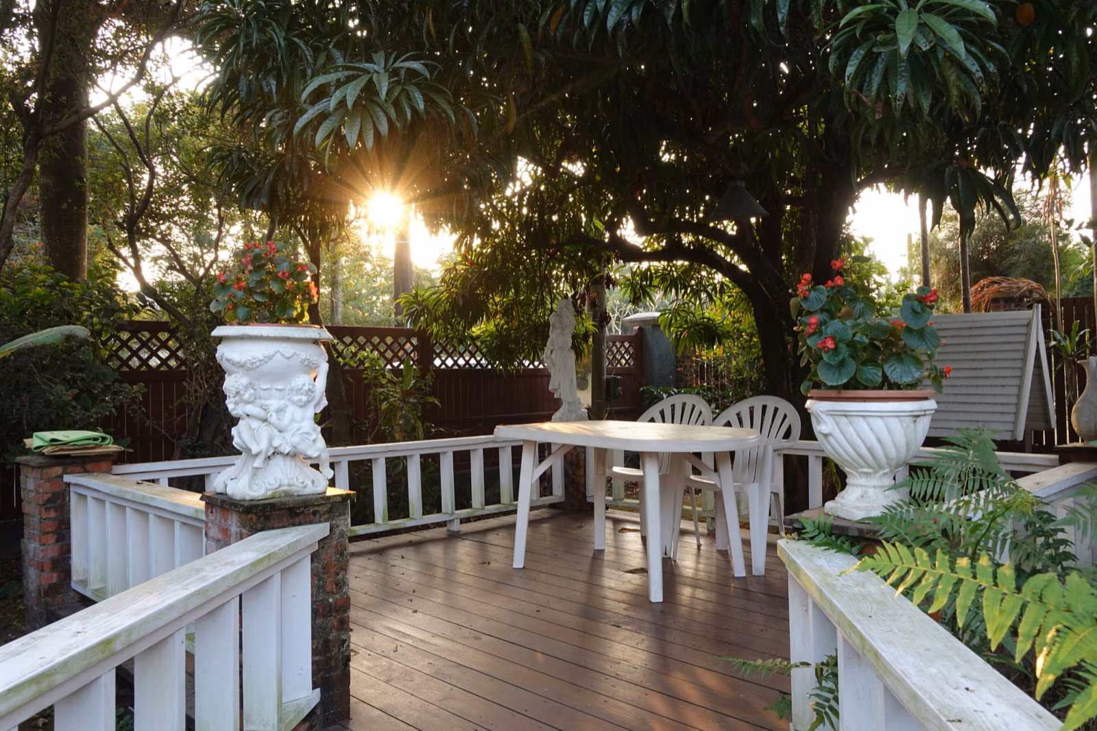 Generate an image of a beautifully renovated outdoor space with a garden, lawn, and patio.