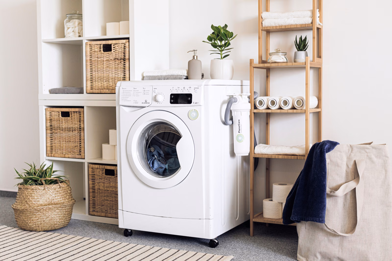 A modern, stylish mudroom and laundry room combination, bathed in soft, warm lighting from recessed fixtures.