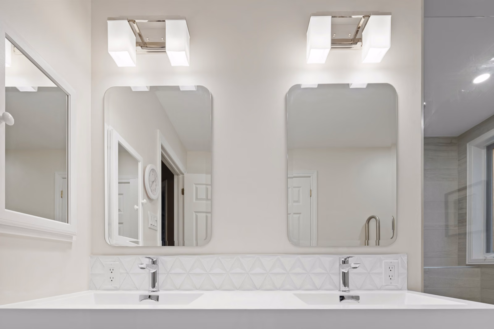 3 bulb vanity light fixtures mounted on a white bathroom
