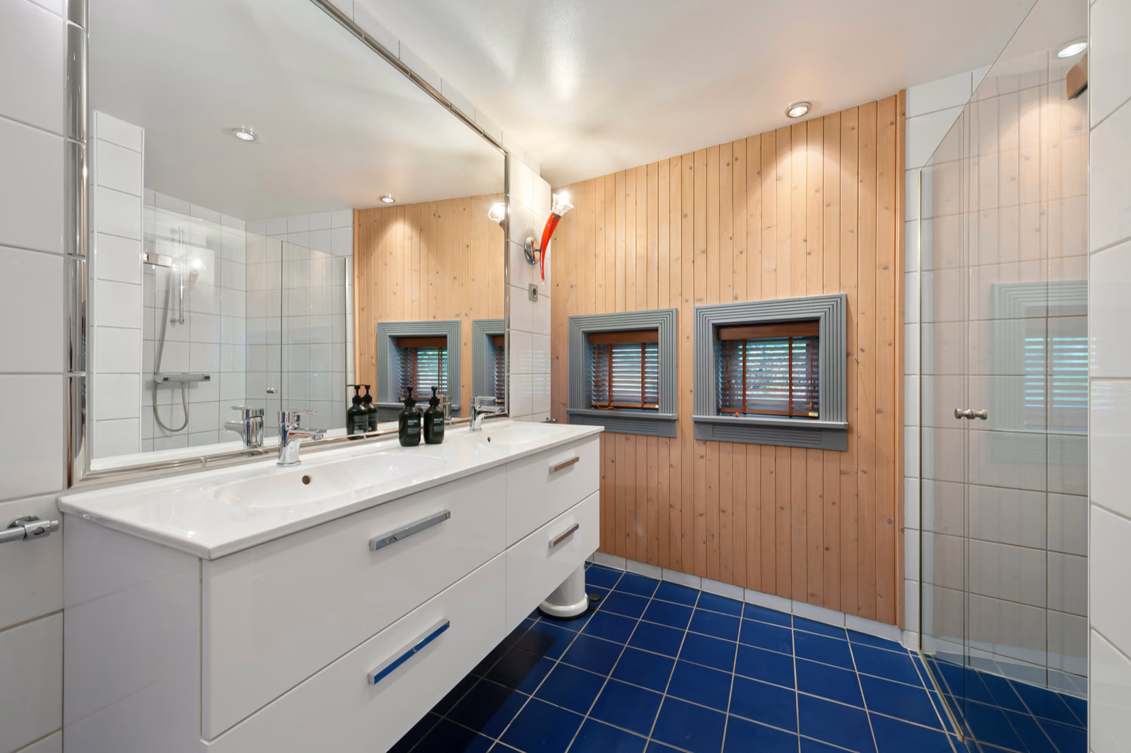 Renotive modern bathroom storage cabinet, with sleek wood and metallic finishes. Well-organized shelves and drawers, ample space for towels, toiletries, and other essentials. Minimalist design with soft, indirect lighting highlighting the clean lines. The cabinet is positioned against a white tiled wall, complemented by a large mirror and simple sink vanity. Subtle pops of greenery add a refreshing touch. The overall mood is one of streamlined efficiency and spa-like serenity, perfect for a 34 bathroom space.