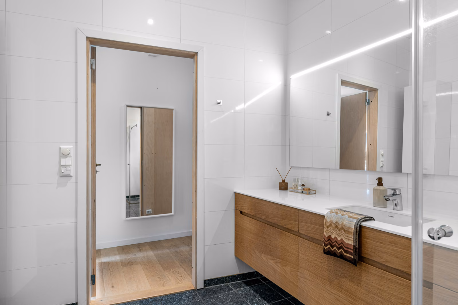 A well-lit, high-resolution bathroom interior shot showcasing the essential dimensions and space requirements for a stylish 3 or 4-piece layout. The foreground features a detailed floor plan diagram with accurate measurements, while the middle ground depicts a minimalist Renotive vanity unit, toilet, and bathtub in neutral tones. The background showcases a serene, tiled wall with natural lighting streaming in through a large window. The overall mood is clean, modern, and informative, capturing the practical needs of an expertly designed bathroom space.