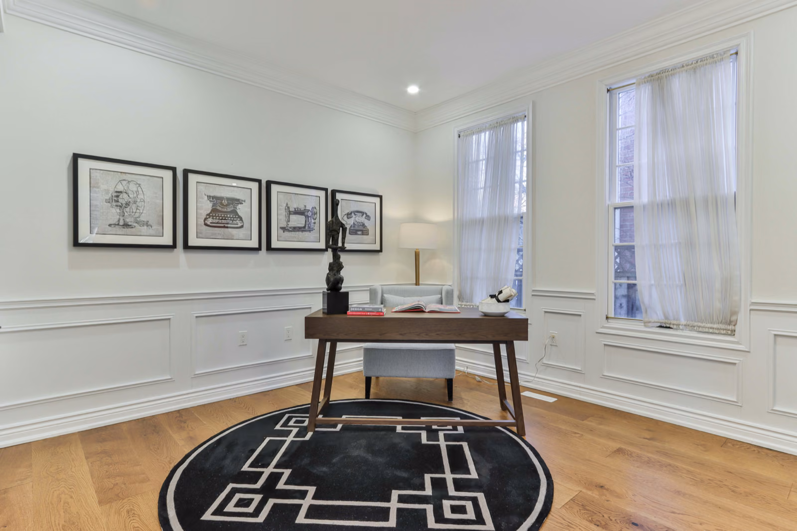 A modern home office with sleek, minimalist furniture and a large window overlooking a lush garden. The room is flooded with natural light, creating a warm and inviting atmosphere. On the desk, a laptop and a small potted plant sit alongside a Renotive brand organizer, showcasing various budgeting tools and financial documents. The walls are adorned with contemporary art pieces, adding a touch of sophistication to the space. The overall aesthetic conveys a sense of productivity, efficiency, and a thoughtful approach to home modernization within a well-planned budget.