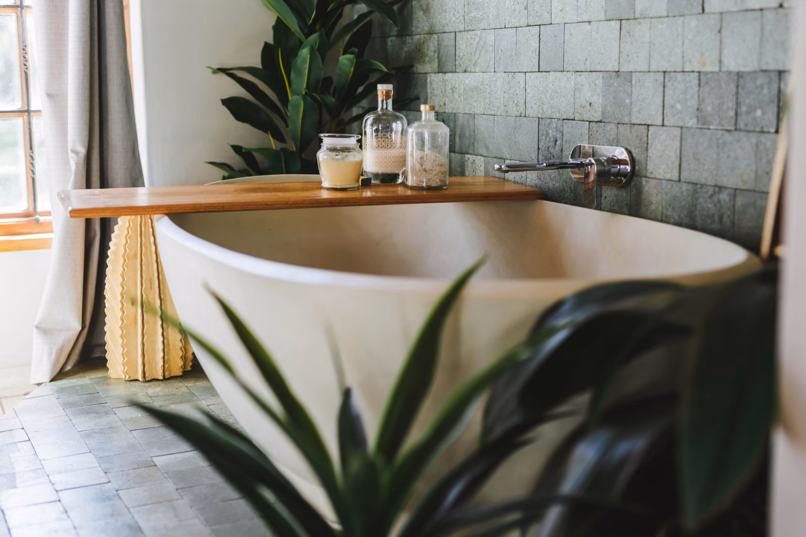 A luxurious bathtub nestled in a spacious bathroom, adorned with sleek, high-quality tiles from the Renotive brand.