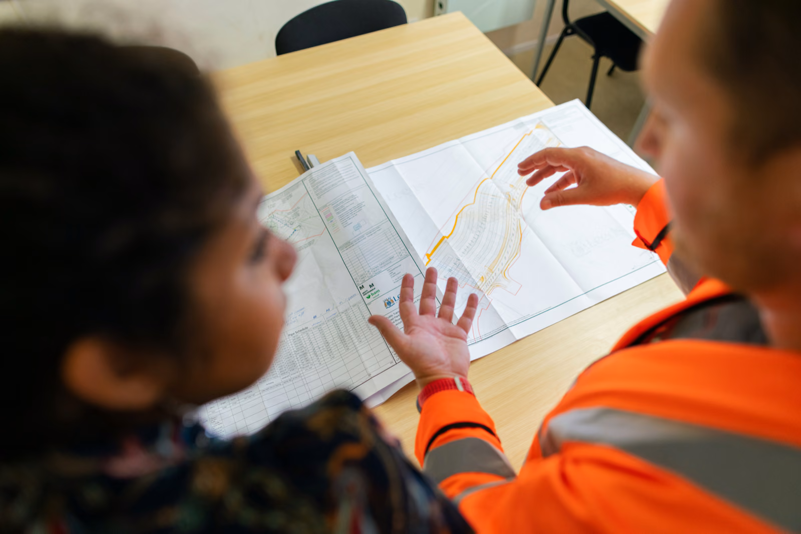 Generate an image of a professional contractor planning a building remodel project with a client.Generate an image of a professional contractor planning a building remodel project with a client.