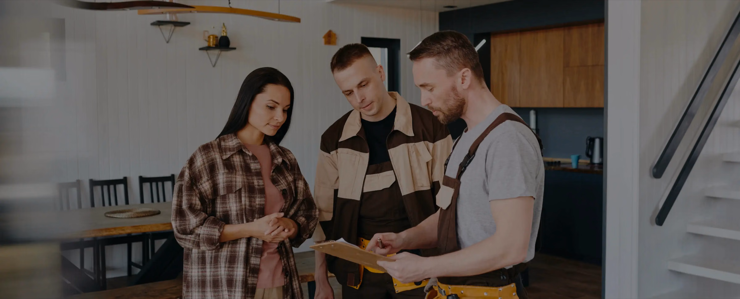 A homeowner reviewing a project checklist with two Renotive builders